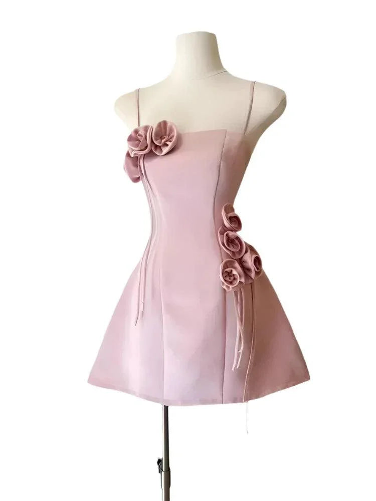 Pink strapless mini party dress with 3D rose details on a mannequin fashion image