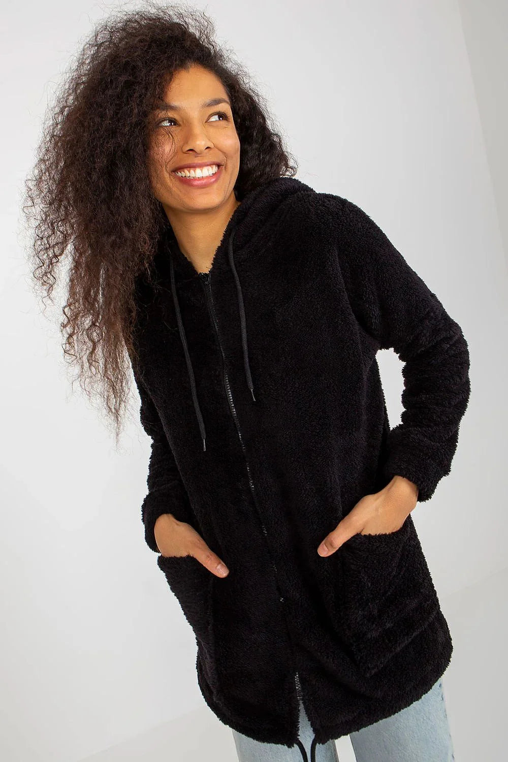 Woman in a black fluffy teddy zip-up hooded jacket with pockets fashion image
