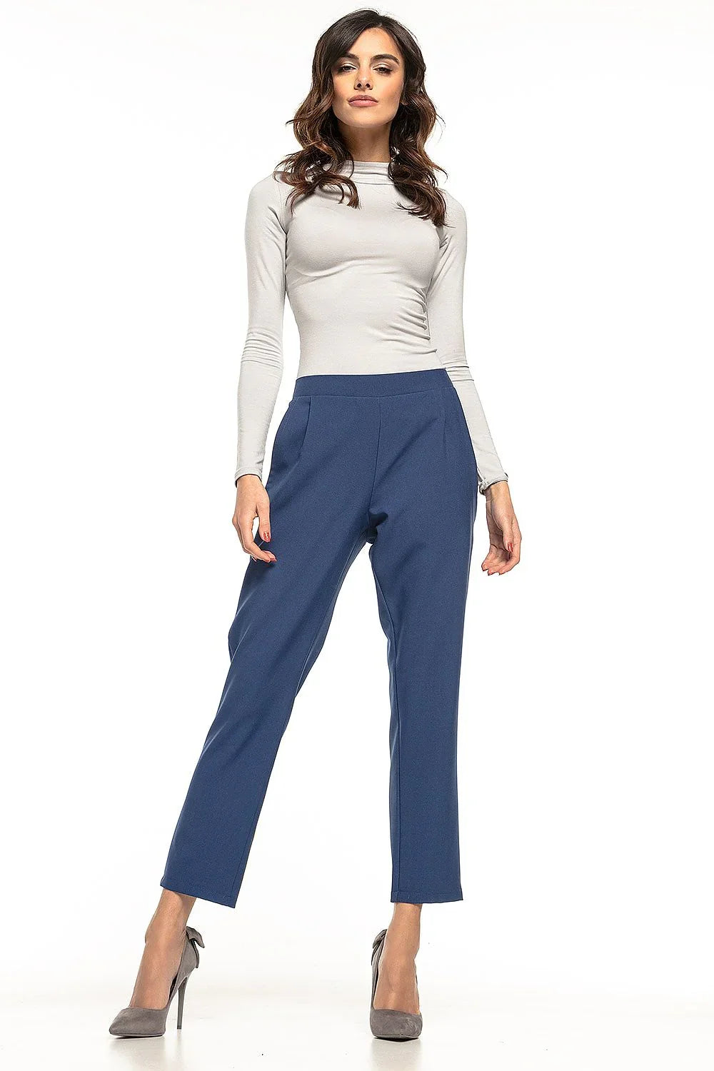 Woman in blue cropped tapered trousers with a grey top and heels fashion image